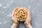 Woman hands holding a wooden bowl with close peanuts. Healthy food and snack. Vegetarian snacks of different nuts