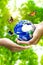 Woman hands holding world or globe give to another hand with butterfly on earth day.Environment conservation and energy saving