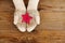 Woman hands in light teal knitted mittens are holding star on snow background.