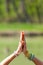 Woman hands with lot of rings and bracelets in yoga mudra gesture namaste greeting outdoor shot sunny day by the lake