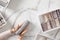 Woman hands neatly folding underwears and sorting in drawer organizers on white marble background.