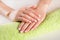 Woman hands with ombre french nails manicure on green towel