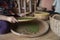 Woman hands over green raw pepper and separates black pepper from red for further drying. Black pepper plants growing on