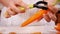Woman hands peel fresh carrot - close up