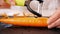 Woman hands peel fresh carrot on cutting board