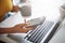 Woman, hands and phone at a laptop for work networking and employee typing. Female worker, table and social network app