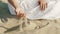 Woman hands playing with sand at beach. Beautiful scene of young boho gypsy girl in white dress with rings touching grit