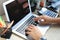 Woman hands pressing keys on a laptop keyboard in office