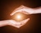 Woman hands protecting and containing bright, glowing, radiant, shining light. Emitting rays or beams expanding of center