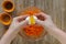 Woman hands put raw egg from broken egg into grated carrot batter for carrot pie on the wooden background