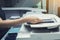 Woman hands putting a sheet of paper into a copying device