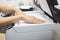 Woman hands putting a sheet of paper into a copying device or printer in the office