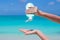 Woman hands putting sunscreen from a suncream bottle