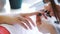 Woman hands receiving a manicure in beauty salon. Nail filing. Close up, selective focus.