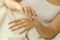 Woman hands rubbing moisturizer cream