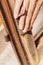 Woman hands sandpaper and repair windows and wooden frames