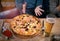 Woman hands showing extra large italian pizza capricciosa