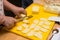 Woman hands slices cheese to make an Italian pizza, process of p