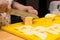 Woman hands slices cheese to make an Italian pizza, process of p