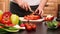 Woman hands slicing red bell pepper for a vegetables salad