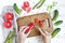 Woman hands slicing sweet pepper on wooden cutting board, surrounded by vegetables. Flat lay, top view