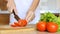 Woman hands slicing tomato in kitchen