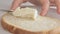 Woman hands spreading cheese cream on bread