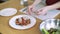 Woman hands spreading salad on a plate in restaurant 4k