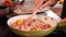 Woman hands stir colorful vegetables mix - cooking a meal