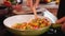 Woman hands stir colorful vegetables mix frying in a pan