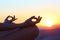 Woman hands at sunset relieving stress doing yoga