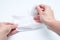 Woman hands taking wet cleaning antibacterial wipes out of package, white background, hygiene and body care concept