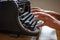 Woman hands type on an old vintage dust-covered typewriter