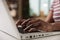 Woman hands typing on laptop keyboard close view