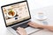 Woman hands typing on laptop keyboard with delivery food screen