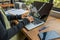 Woman hands typing laptop next to cellphone on wood table