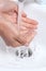 Woman hands under a waterjet