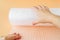 Woman hands unwind a roll of white transparent bubble wrap on a yellow background. Material for packing fragile items for safe