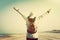 Woman with hands up wearing retro backpack on the beach