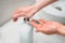 Woman hands using soap dispenser for cleaning hands at home