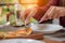 Woman hands using spoon and fork taking slices of pizza