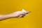 Woman hands wiping palm with napkin turned up gesture on yellow background.