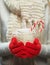 Woman hands in woolen red gloves holding cozy mug with hot cocoa, tea or coffee and candy cane. Winter and Christmas time concept.