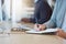 Woman, hands and writing in book for business tasks, reminder or schedule at the office desk. Hand of female taking