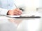 Woman hands writing on clipboard with a pen, isolated