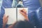 Woman hands writing on notepad lying at home .