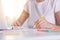 Woman hands with yellow pen writing something on peper, working online, female wearing white casual t shirt working on laptop and