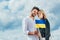 Woman and handsome man holding ukrainian flag outside