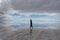 Woman in handstand in centre of view of Salar De Uyuni Saltflats, Bolivia, with water reflecting sky and mountains