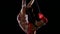 Woman hanging in ring for aerial acrobatics. Black background. Slow motion. Close Up
